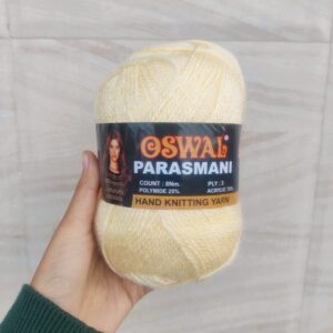 Hand holding skein of Oswal yellow knitting yarn.