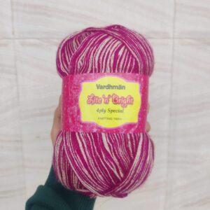 Hand holding Vardhman knitting yarn in pink shade.