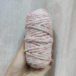Hand holding multicolored yarn skein.