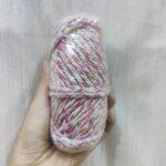 Hand holding colorful yarn skein for crafting.
