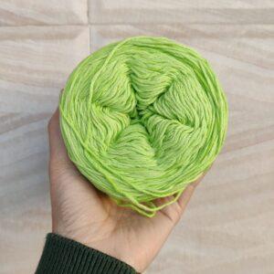 Hand holding green yarn ball